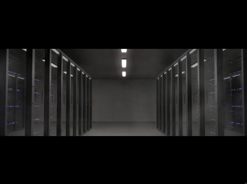 A darkened room featuring several rows of servers, illustrating a modern data storage facility.